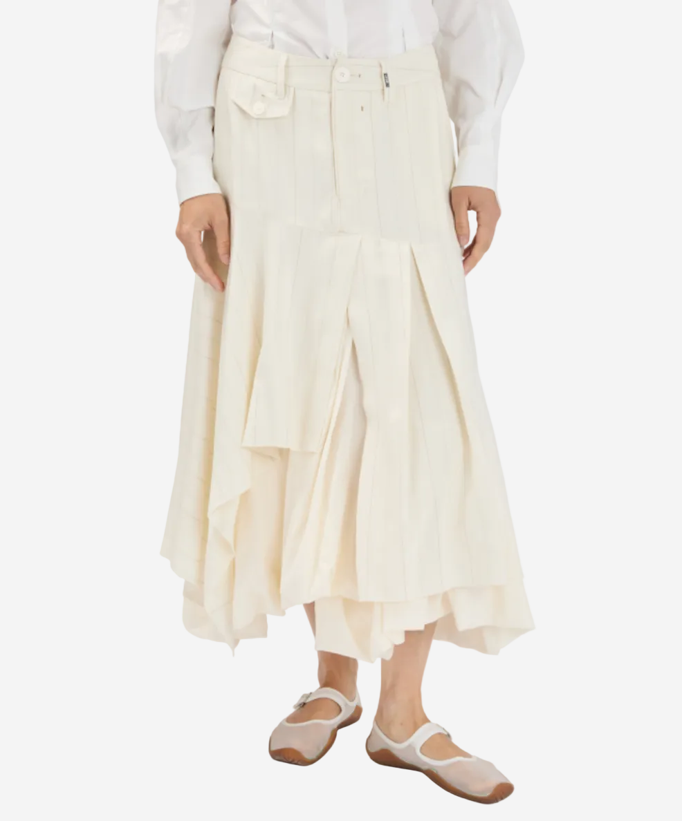 Person wearing a white skirt and white shirt on a plain background