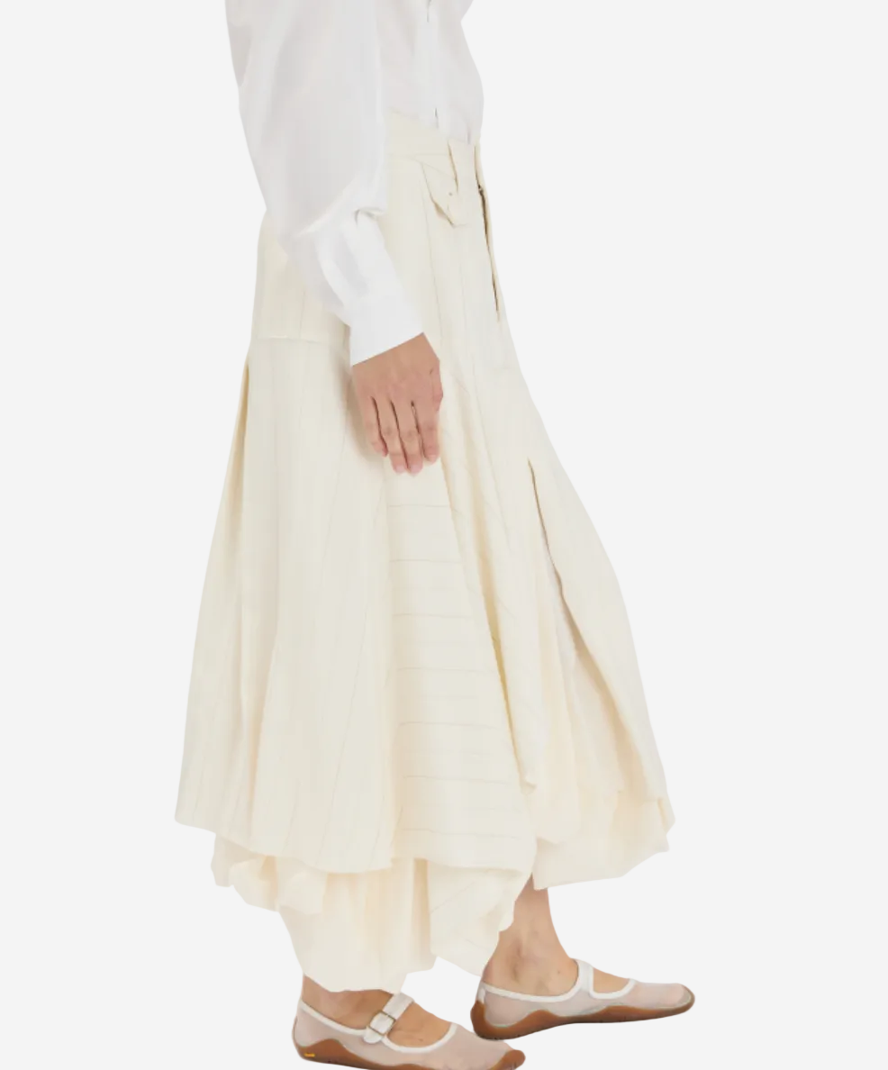 Person wearing a white top and beige skirt on a white background