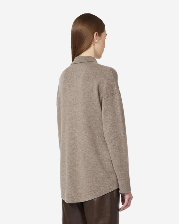 Person wearing a beige sweater on a white background
