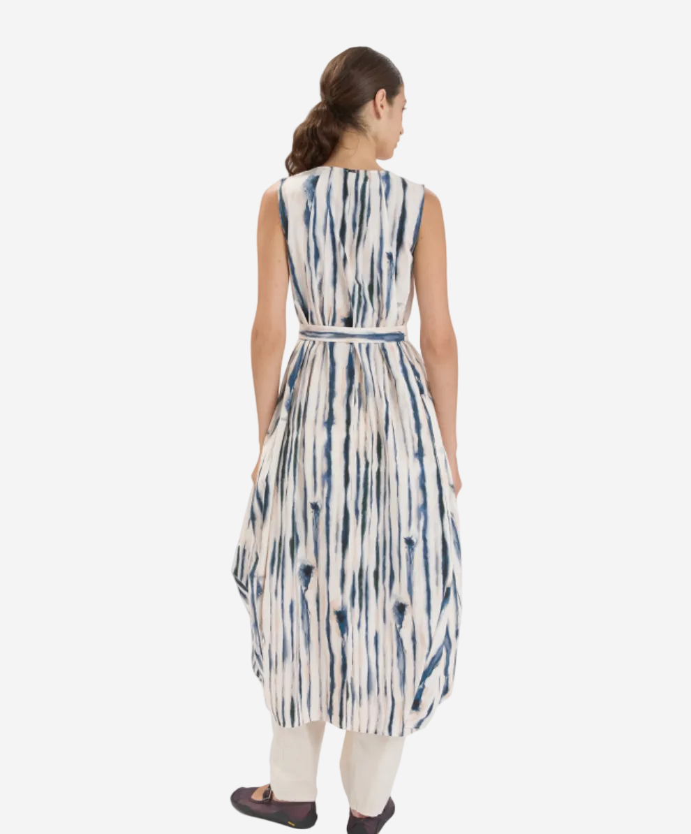 Woman wearing a sleeveless dress with blue and white pattern on a white background