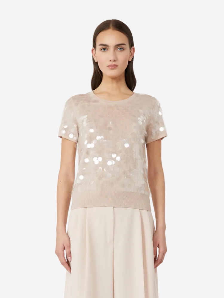 Woman wearing a beige sequin top and skirt set on a white background