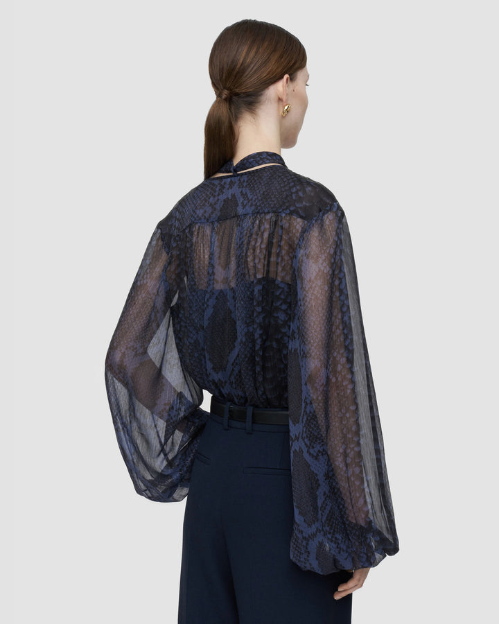 Back view of the JOSEPH Sally sheer blouse showing the full blouson sleeves and snake print