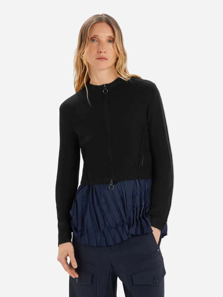 Woman wearing a black and navy layered outfit on a white background
