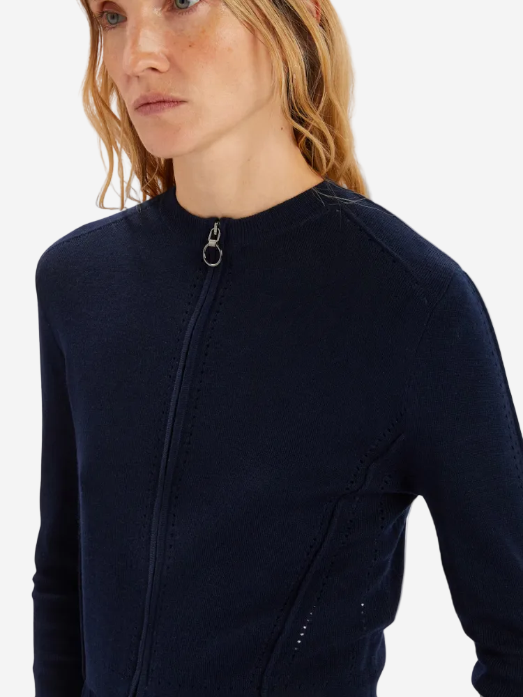Person wearing a navy blue long-sleeve top with a zipper on a white background