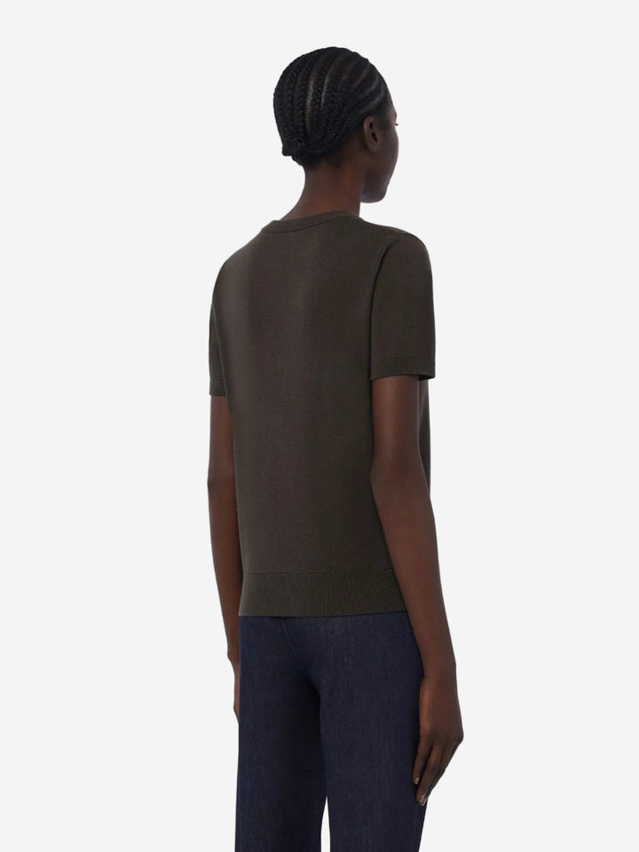 Person wearing a dark green t-shirt and dark pants on a white background