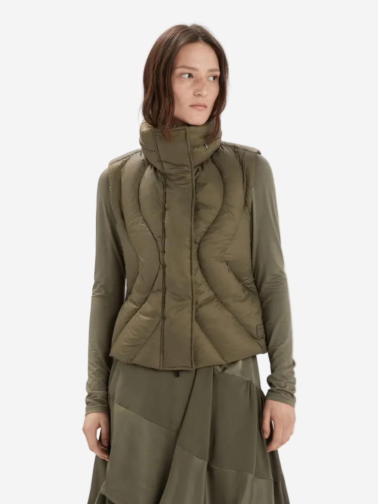 Woman wearing a green quilted jacket and skirt on a white background