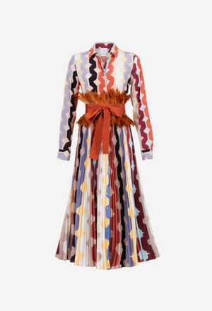 Woman wearing a colorful patterned dress with a red belt on a white background