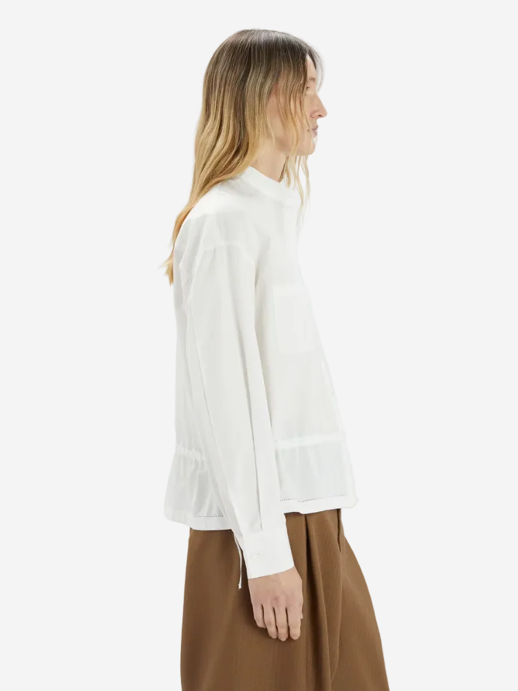 Woman wearing a white blouse and brown skirt on a white background