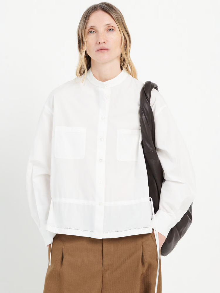 Person wearing a white shirt with a black sleeve against a white background