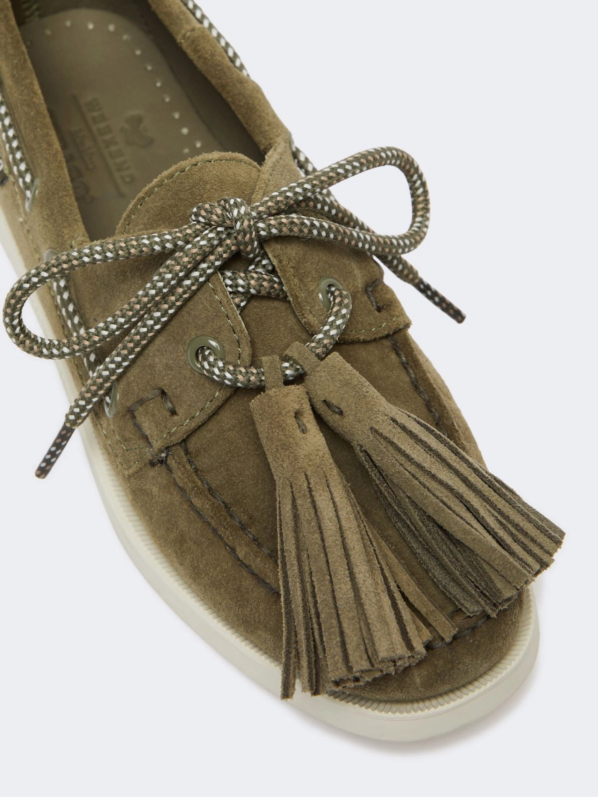 Brown suede shoe with tassel and lace on a white background