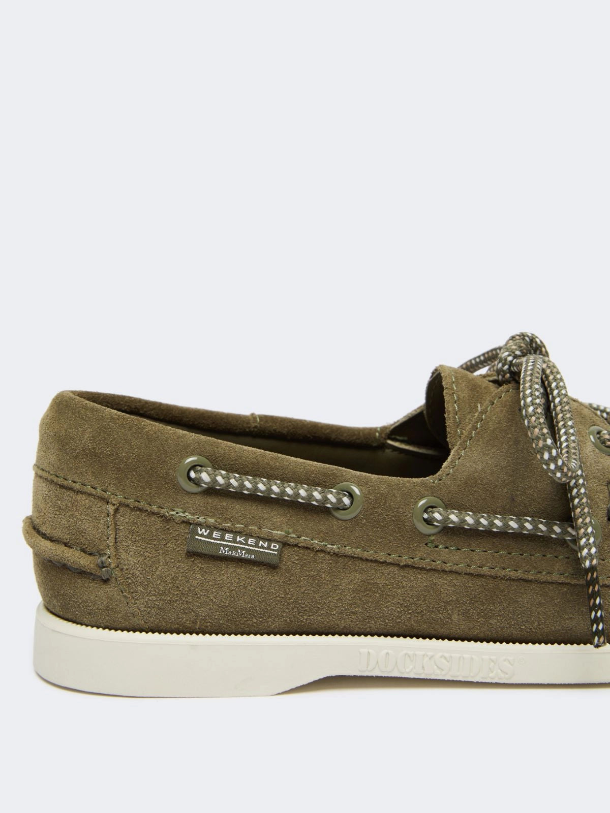 Brown boat shoe with decorative elements on a white background