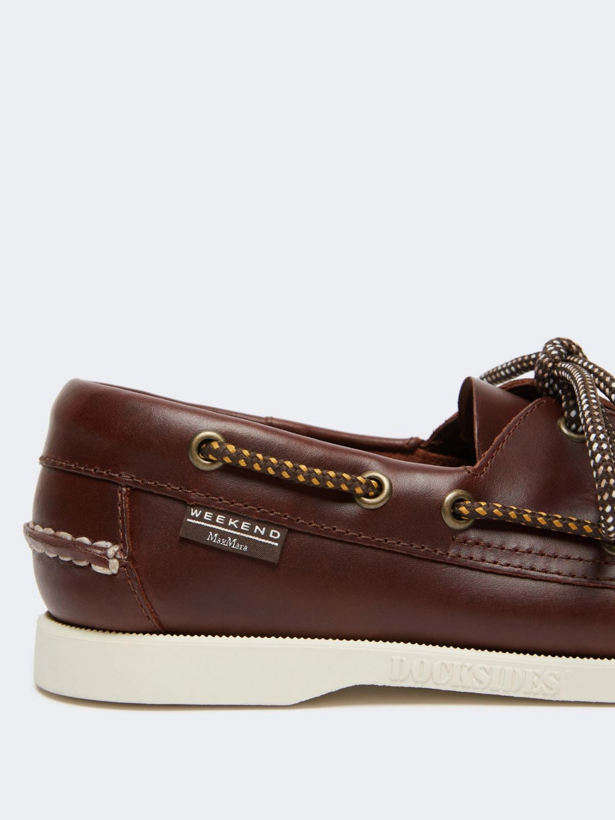 Brown leather boat shoe with decorative chain on a white background at Christensen Copenhagne
