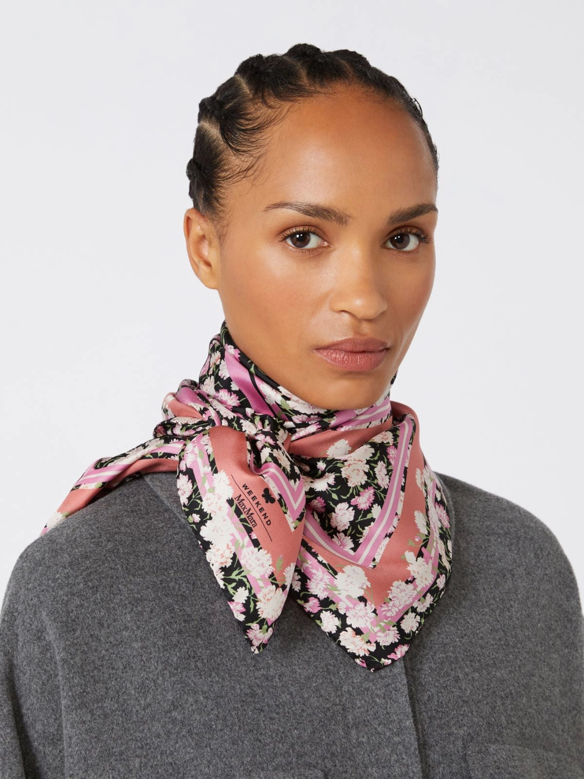 Woman wearing a floral scarf on a plain background