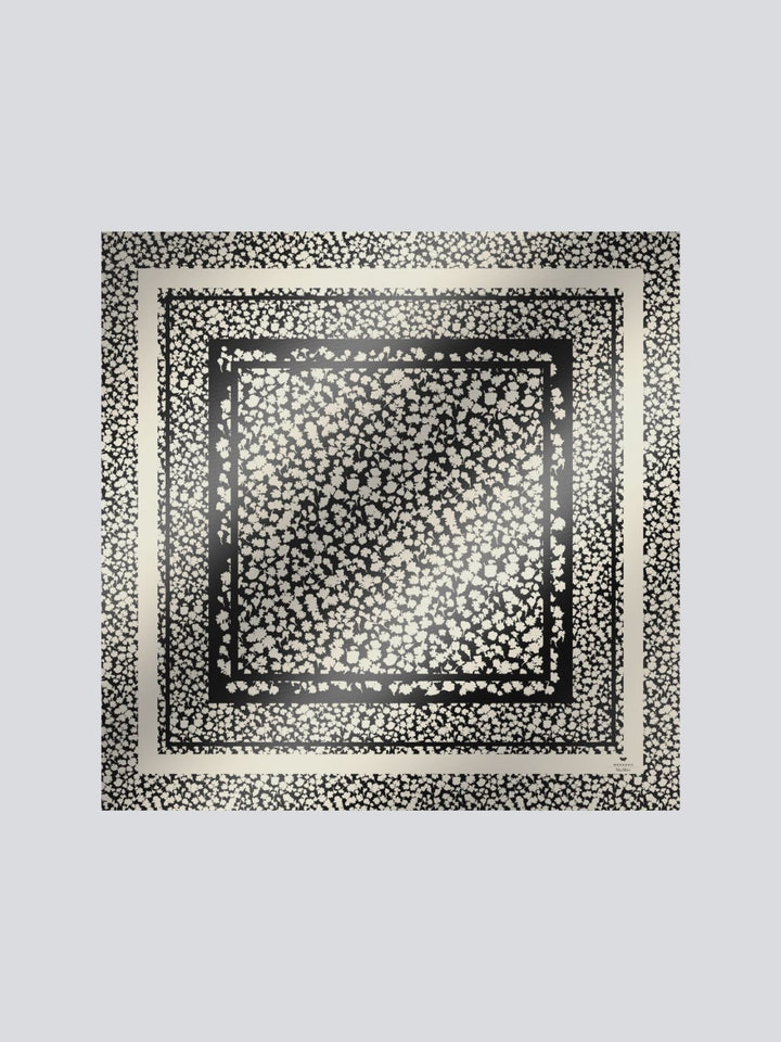 Black and white patterned square scarf on a light gray background