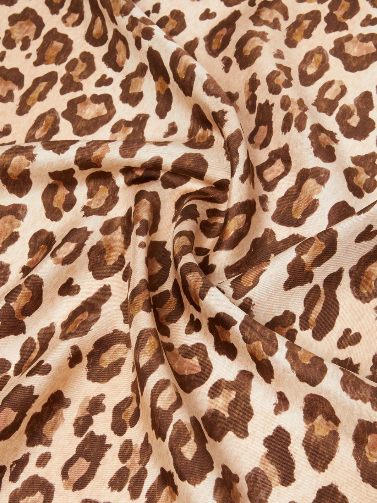 Leopard print fabric with brown and beige spots on a beige background