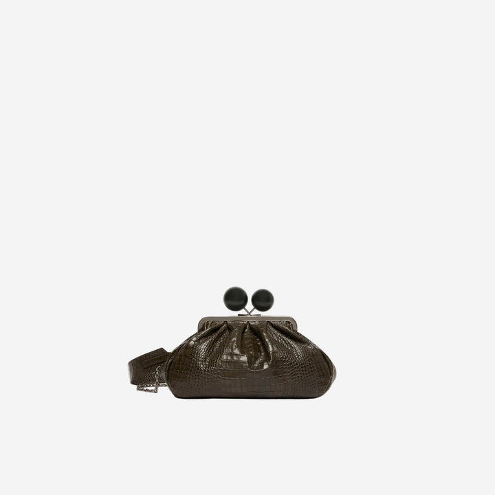 Brown clutch bag with black pom-pom details on a white background
