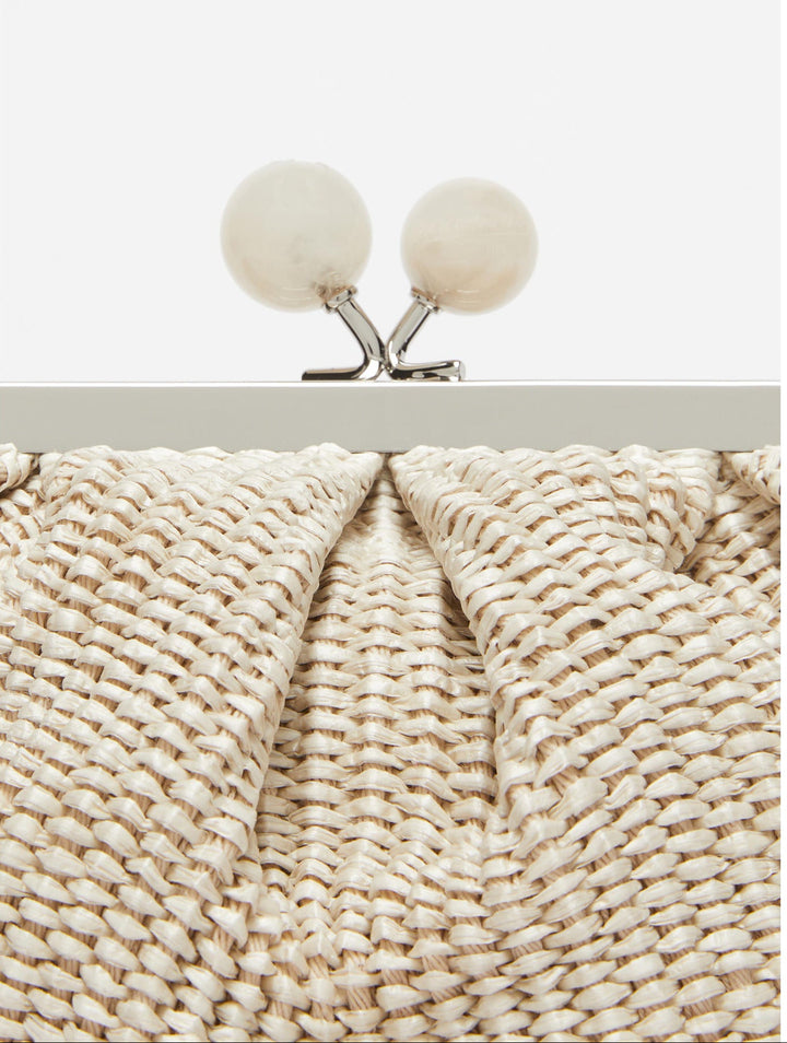 Close-up of a textured clutch bag with a metallic frame and spherical clasps.