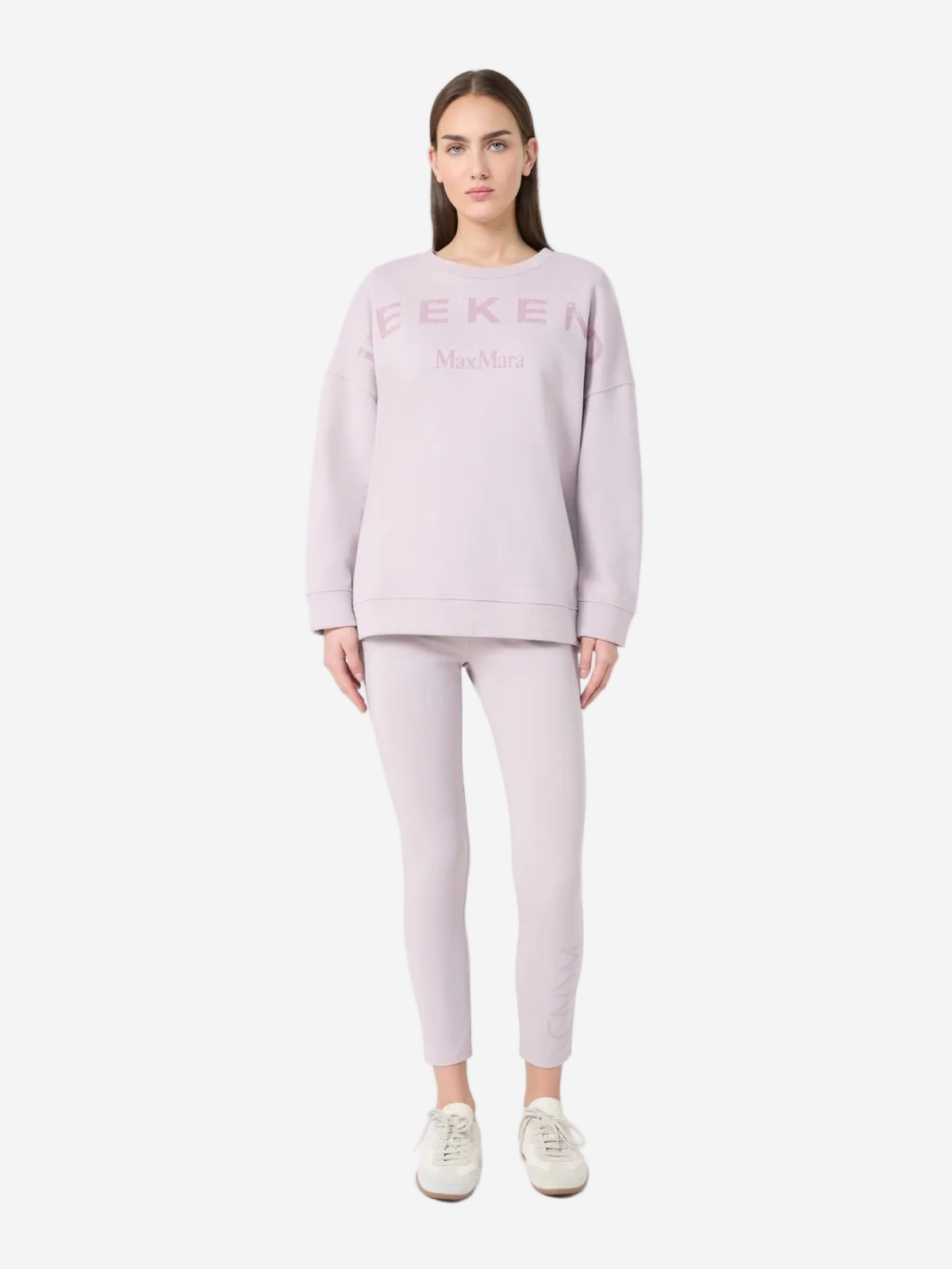 Woman wearing a light purple sweatshirt and leggings with 'EEKER' branding on a white background