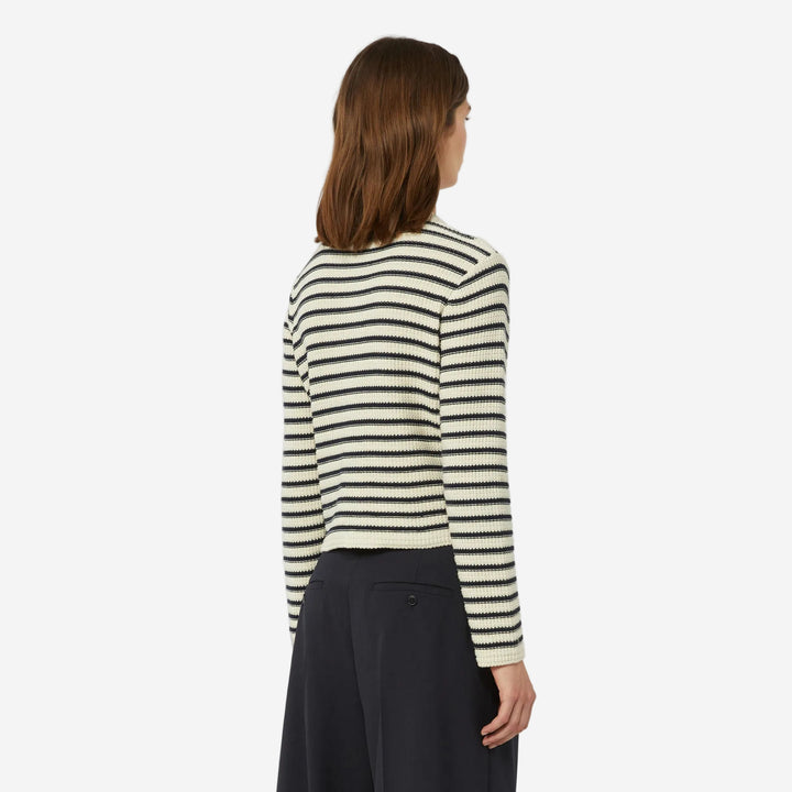 Woman wearing a striped sweater and dark pants on a white background
