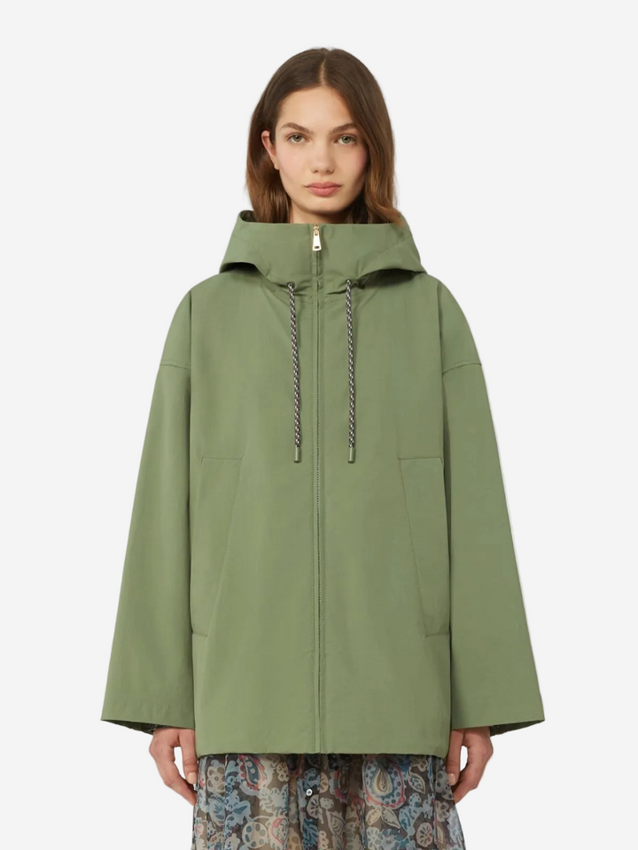 Woman wearing a green raincoat on a white background