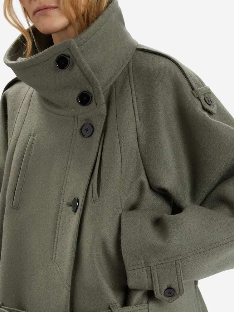 Close-up of a green coat with buttons on a white background