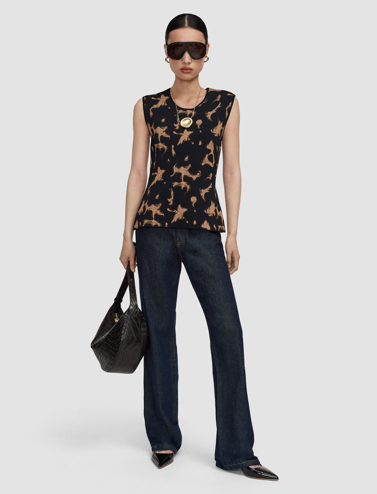 A model wearing a sleeveless black top with a tan tortoise print from Joseph. 