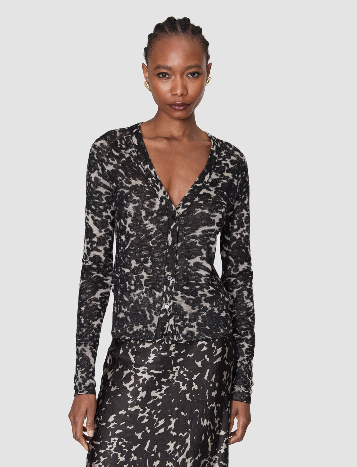 A woman modeling a long-sleeve cardigan with a white abstract brushstroke pattern by Joseph.