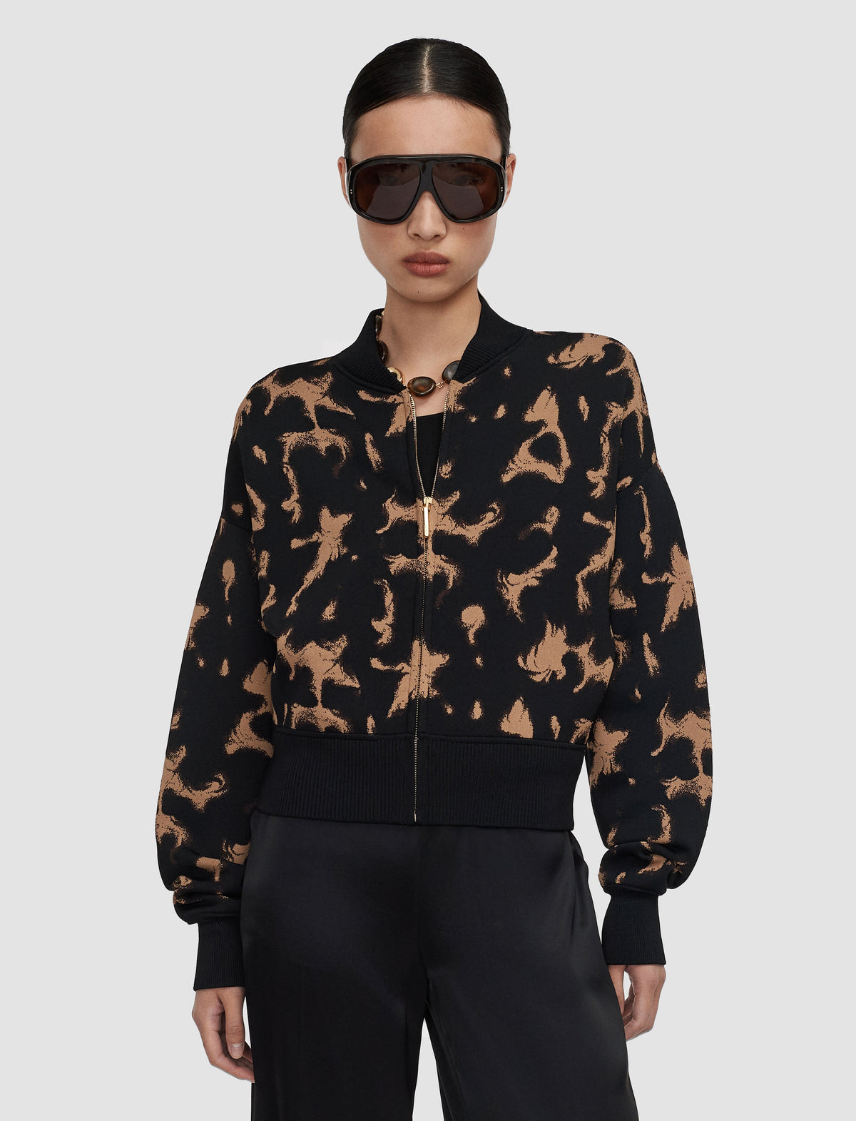 A model wearing a black and tan tortoise patterned bomber jacket from Christensen Copenhagen. 