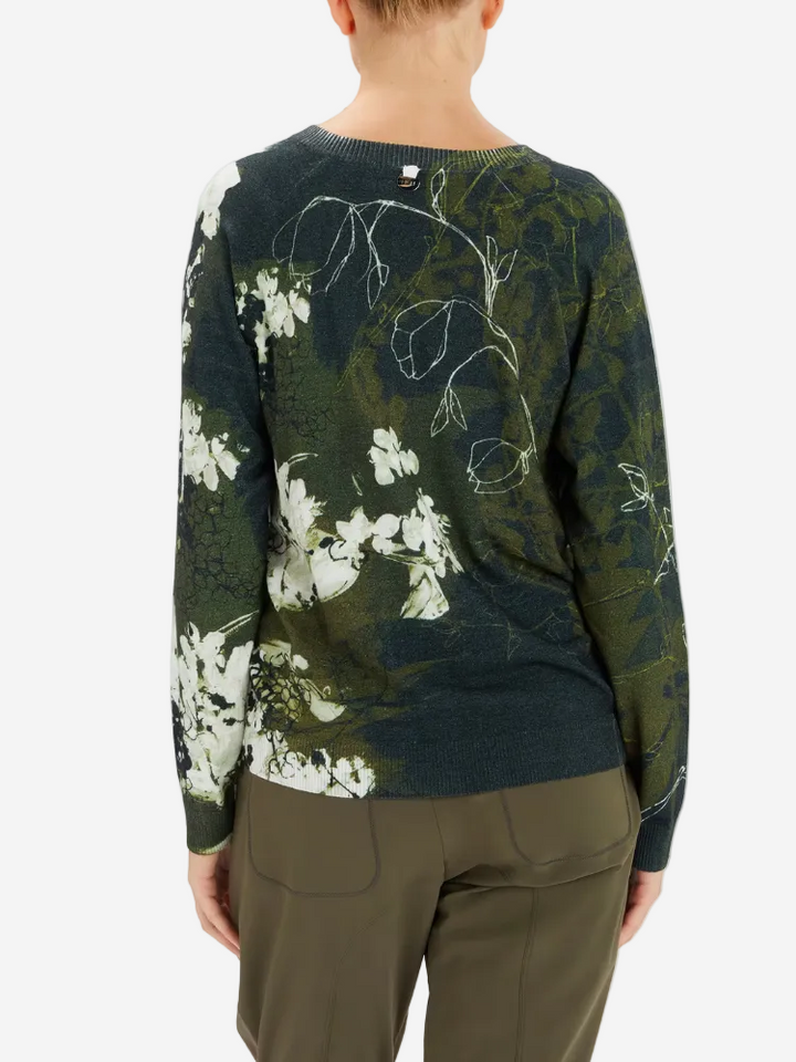 Person wearing a green floral-patterned sweater on a white background