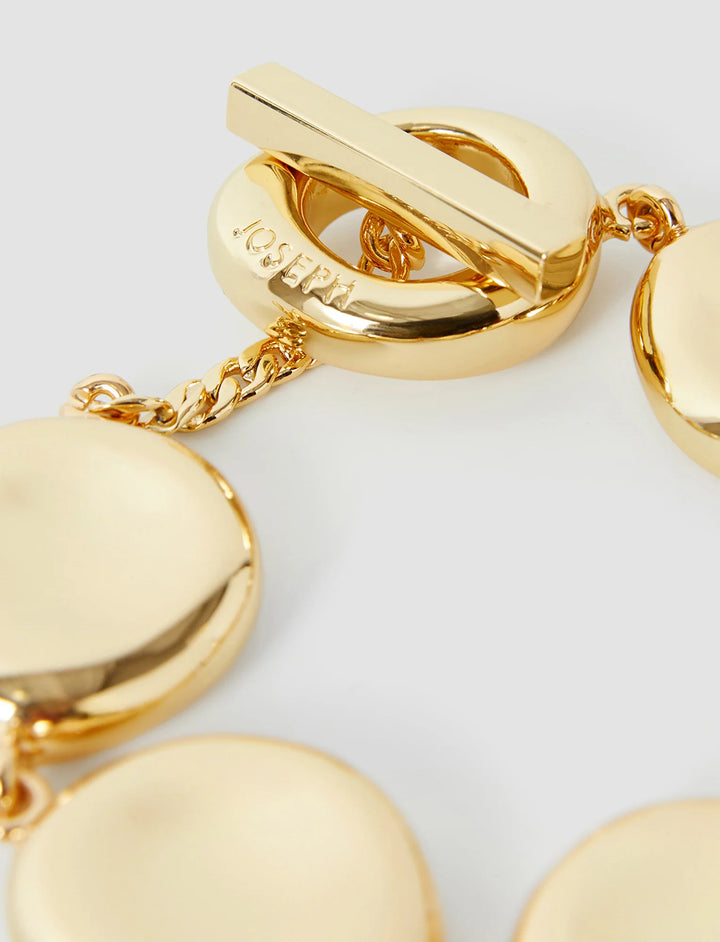 Gold bracelet with heart-shaped links on a light gray background