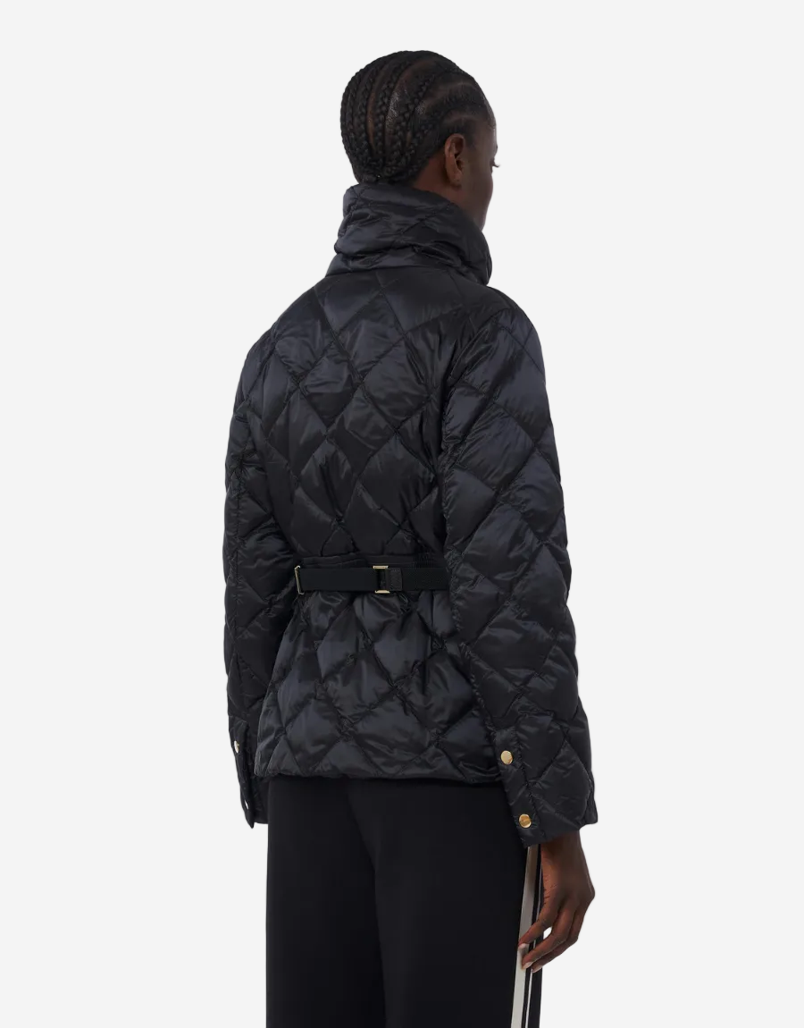 Person wearing a black quilted jacket on a white background