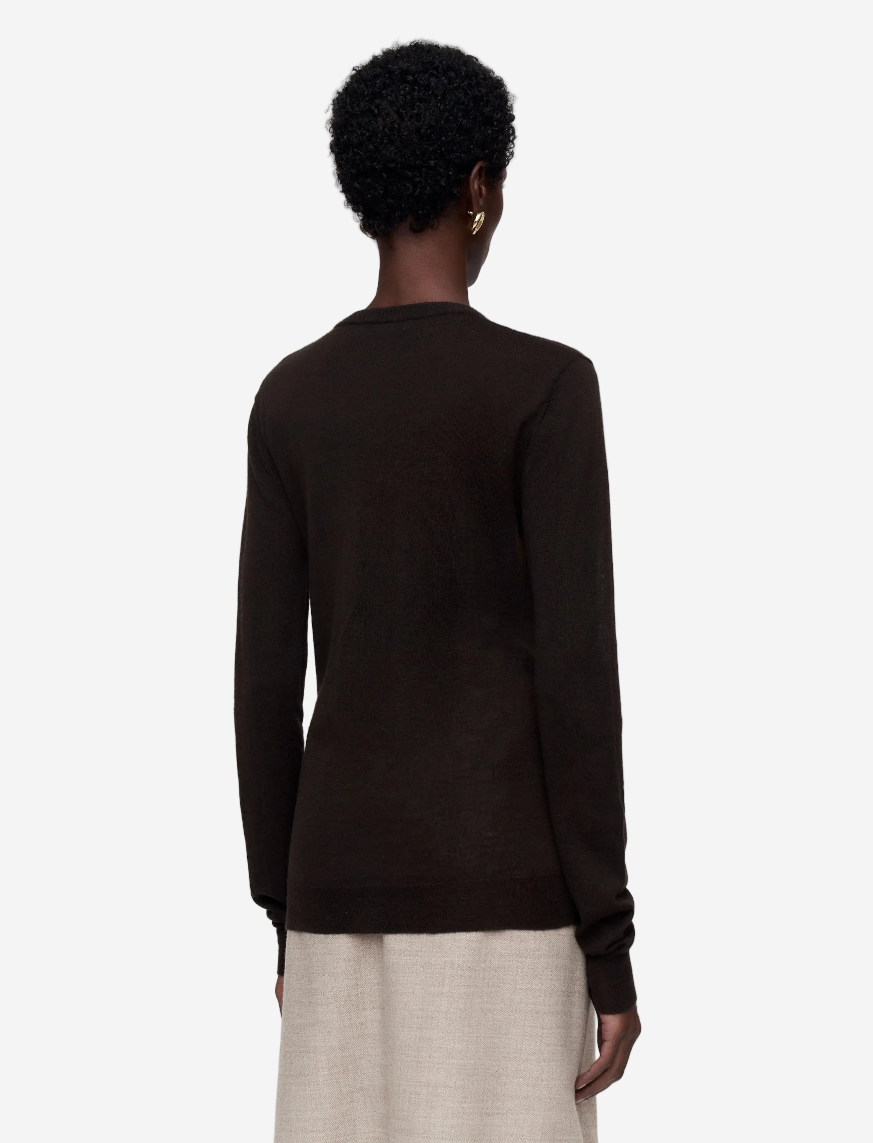 Person wearing a dark brown sweater on a light gray background
