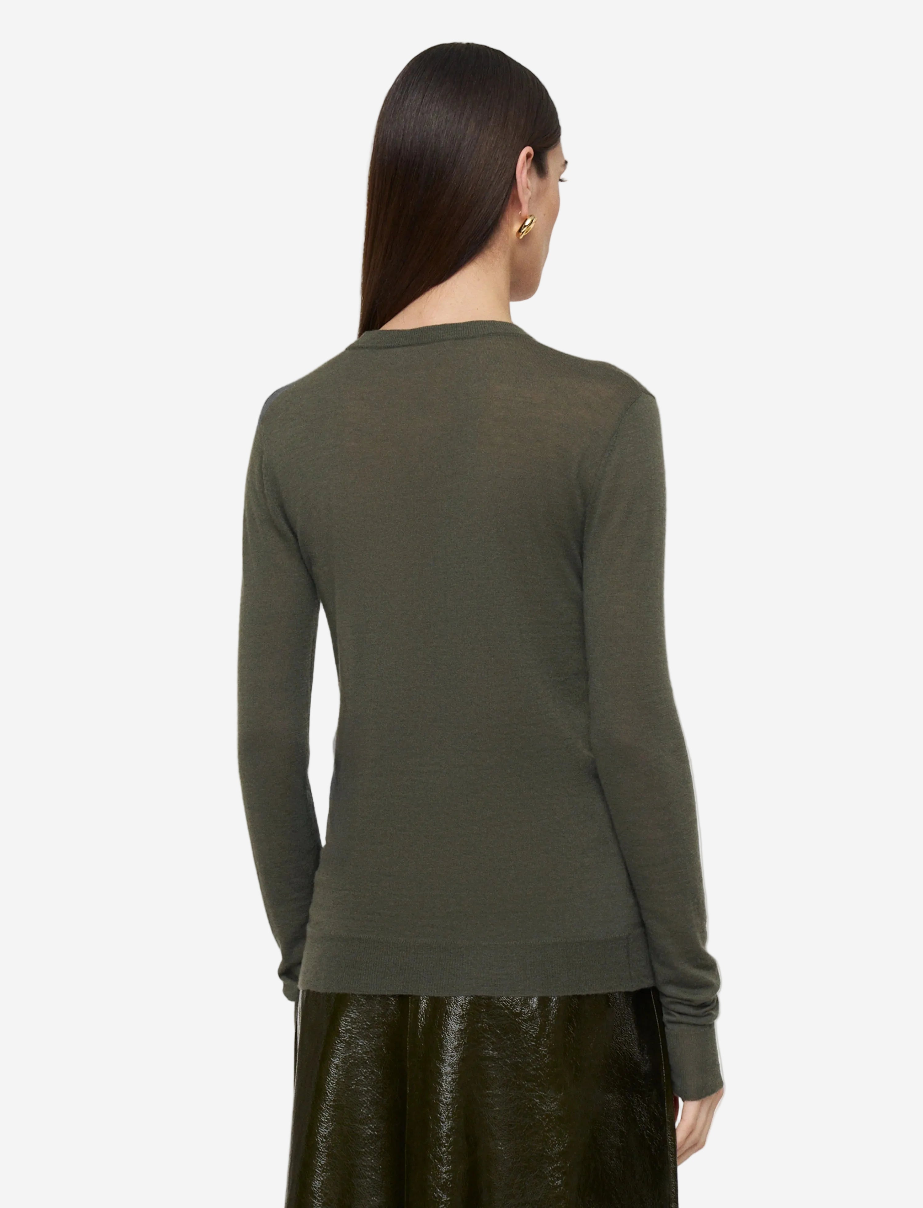 Woman wearing a green sweater on a light gray background