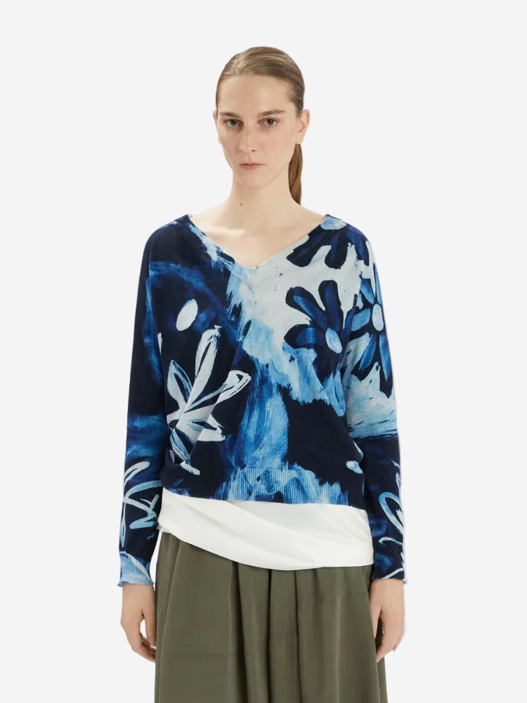 Woman wearing a blue and white floral-patterned sweater on a white background