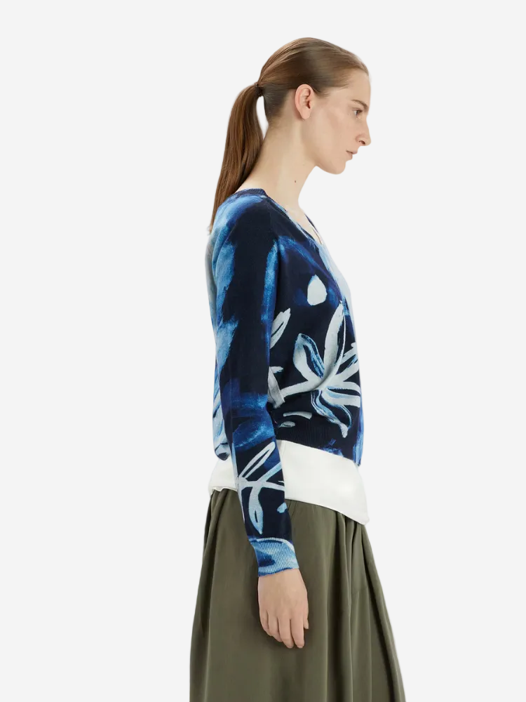 Woman wearing a blue tie-dye cardigan with white patterns on a white background