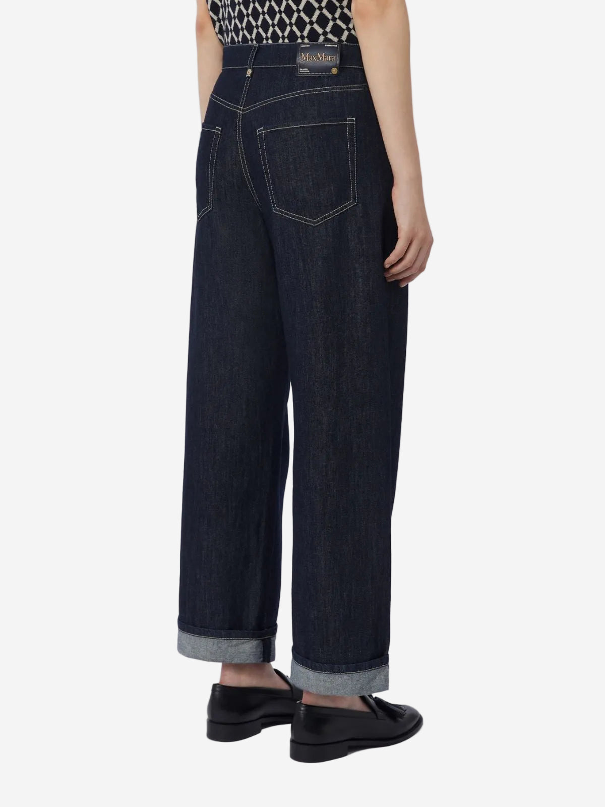 Person wearing dark blue jeans on a white background