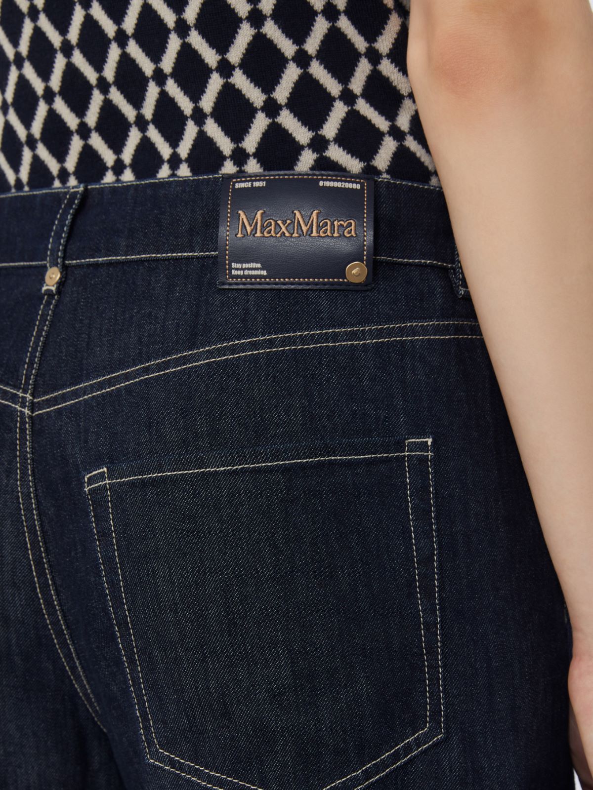 Dark blue jeans with Max Mara label on a patterned background