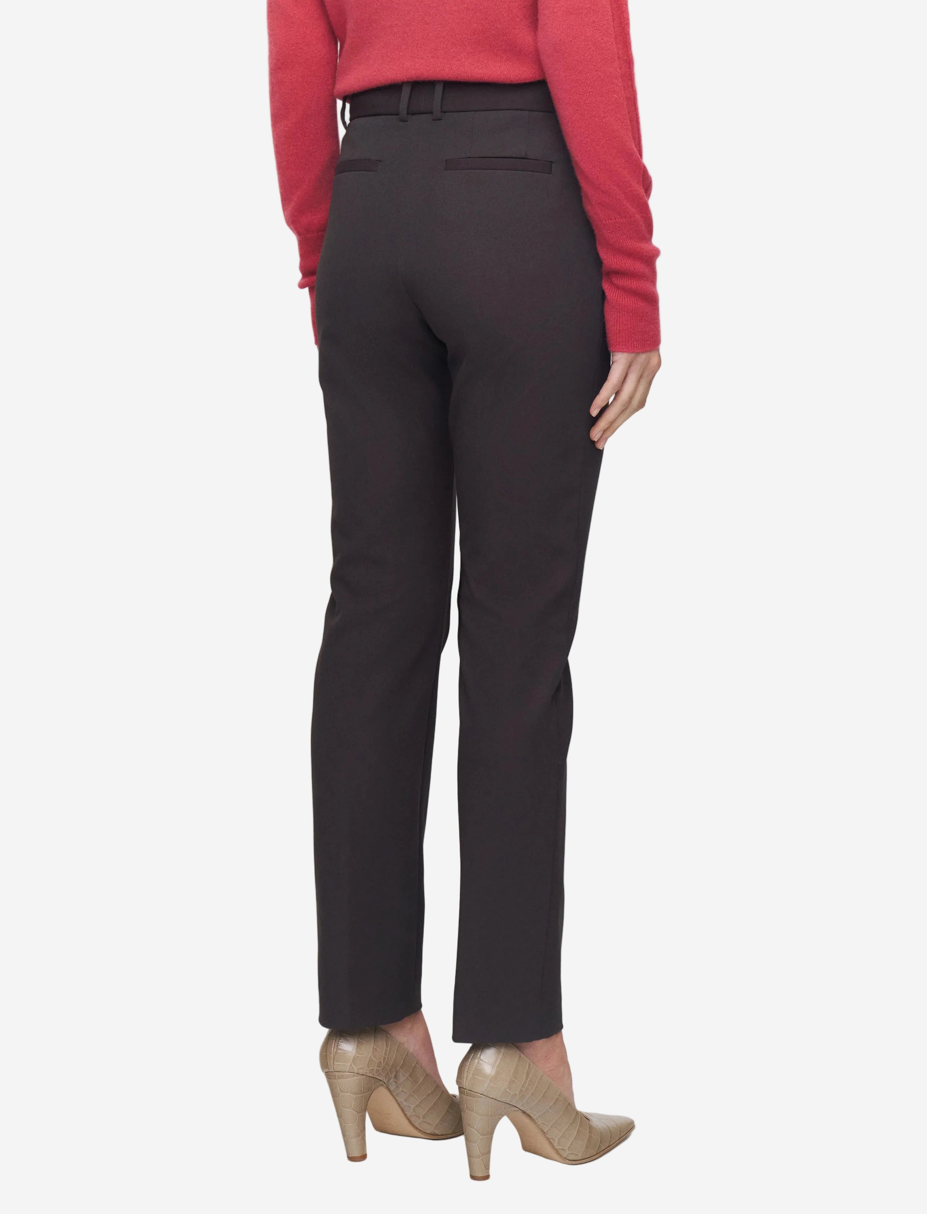 Person wearing black pants and a red top on a white background
