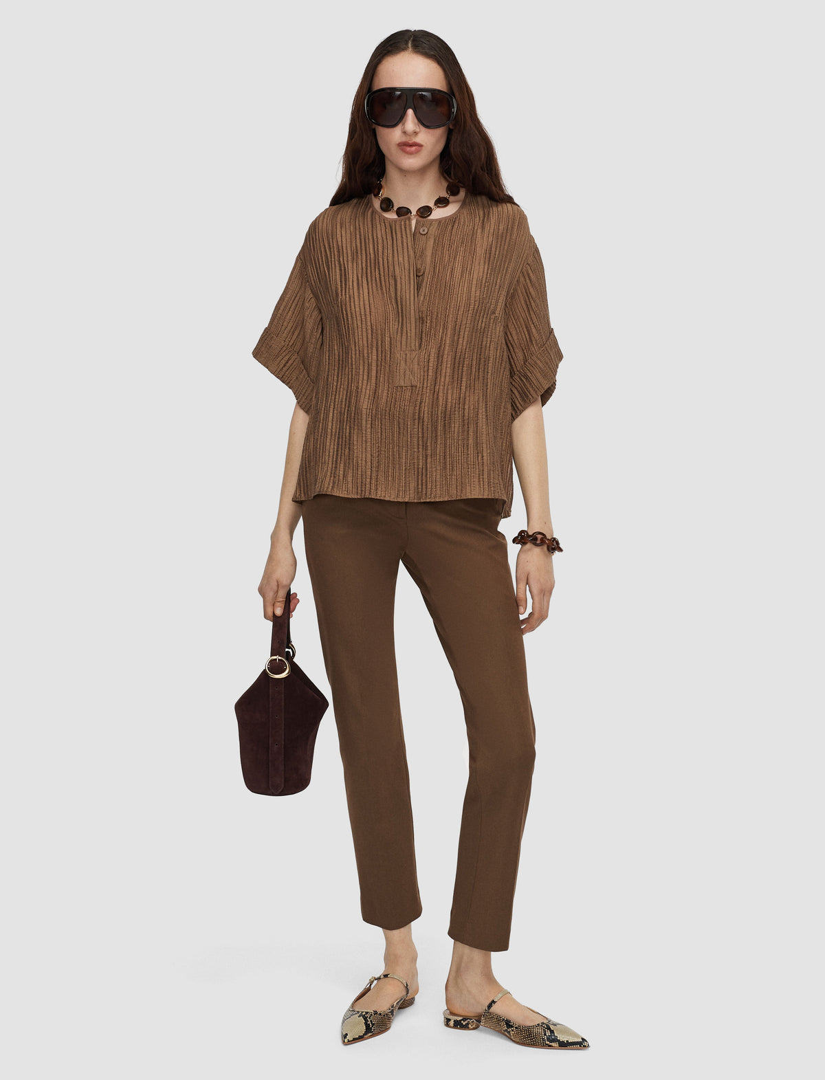 Model wearing taupe trousers by Joseph. 