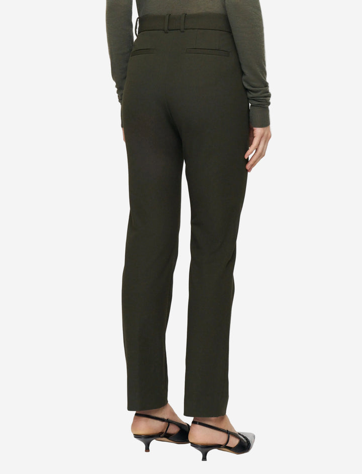Green pants worn by a person on a white background