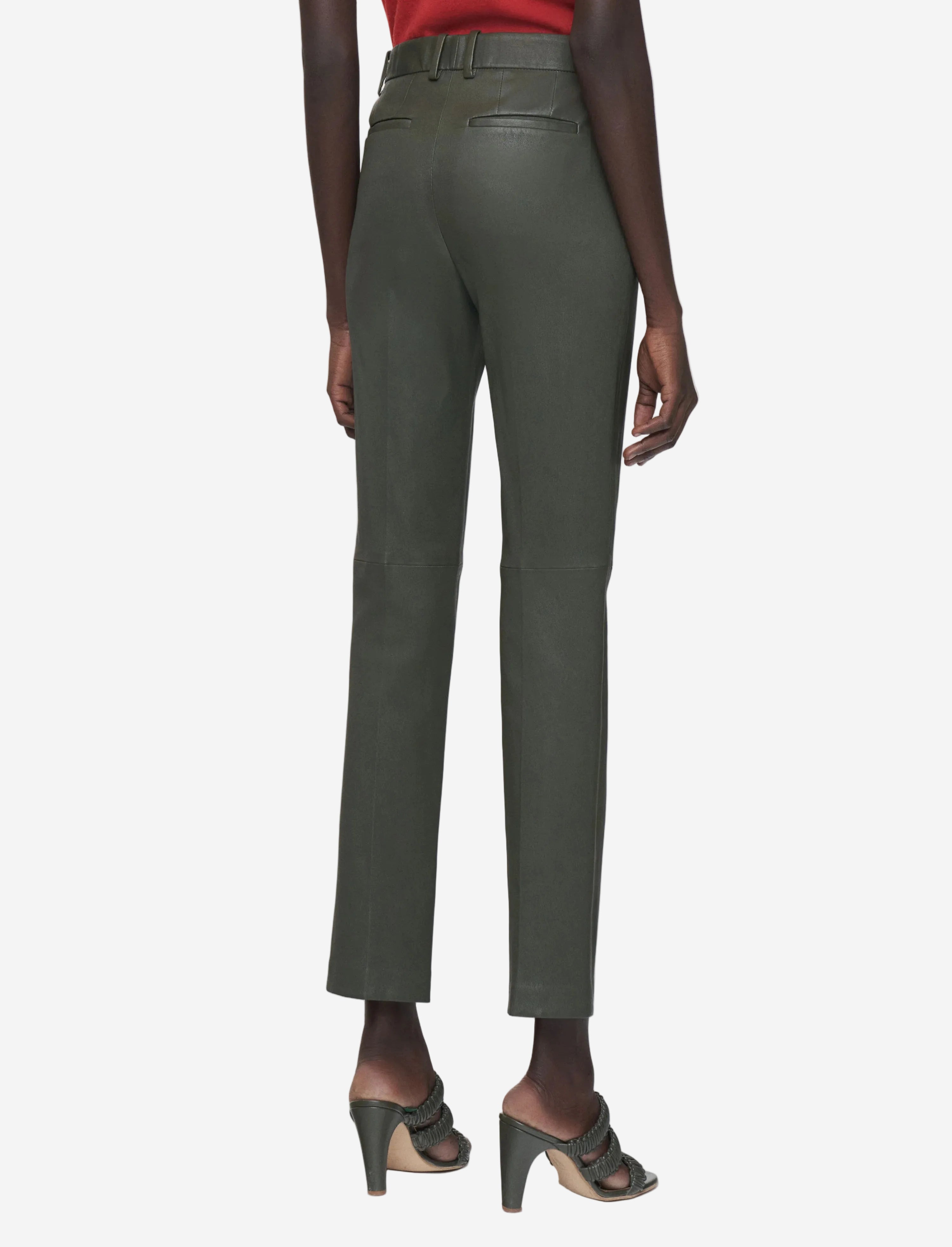 Green pants worn by a person on a white background