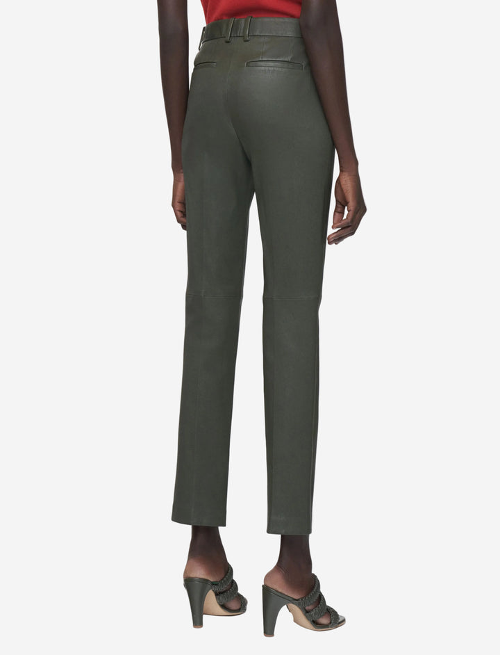 Green pants worn by a person on a white background