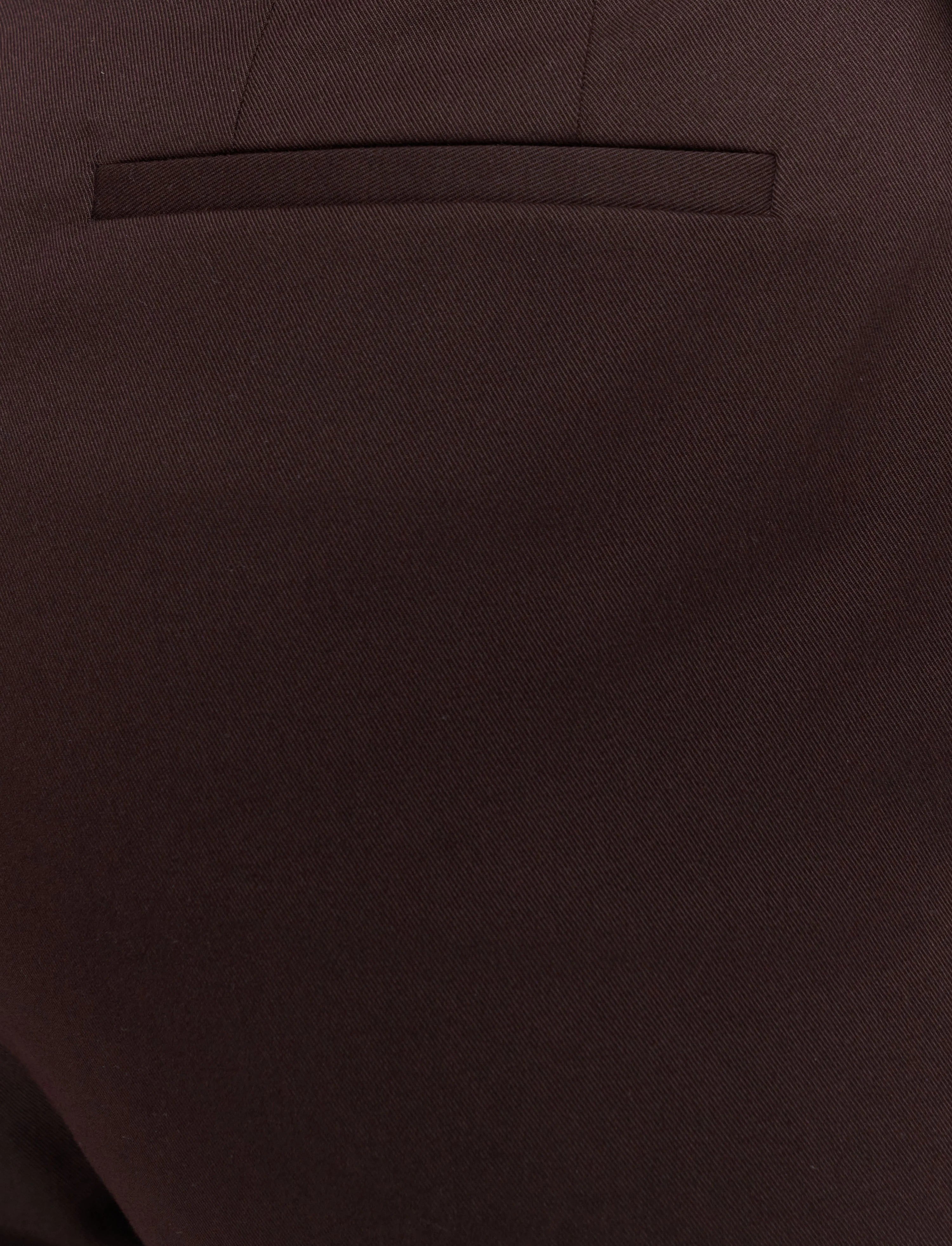 Close-up of a brown suit pocket with a plain background