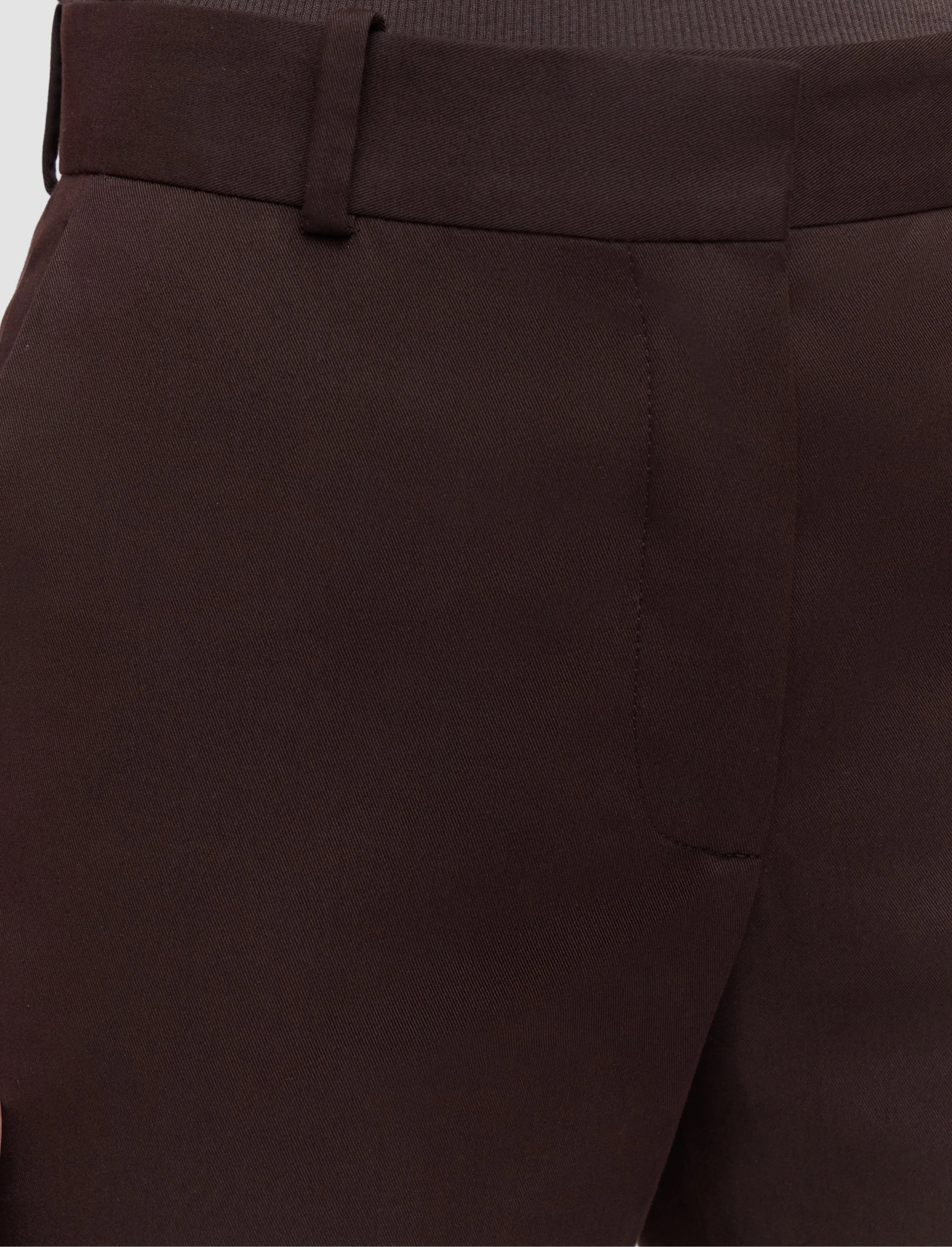 Close-up of brown pants with a white background