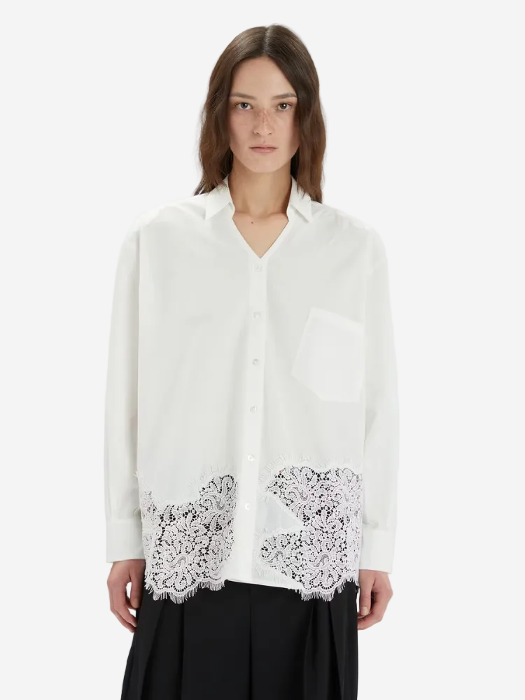Woman wearing a white blouse with lace details on a white background