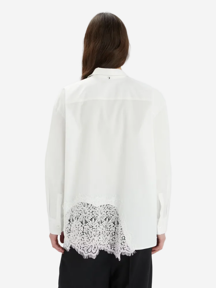 White blouse with lace detailing on a white background
