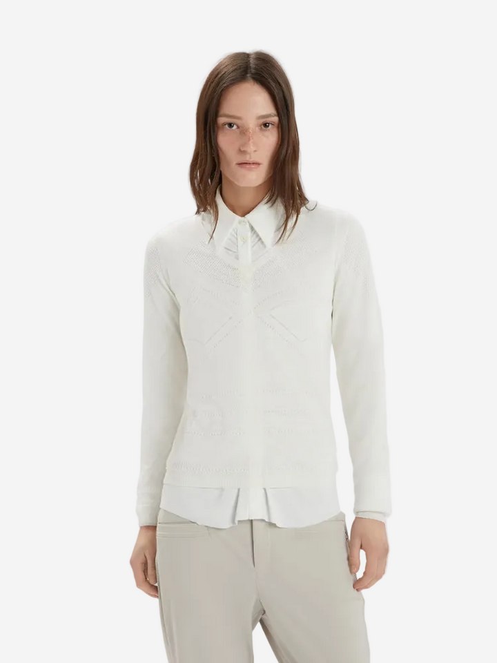 Woman wearing a white blouse with a collar on a plain background