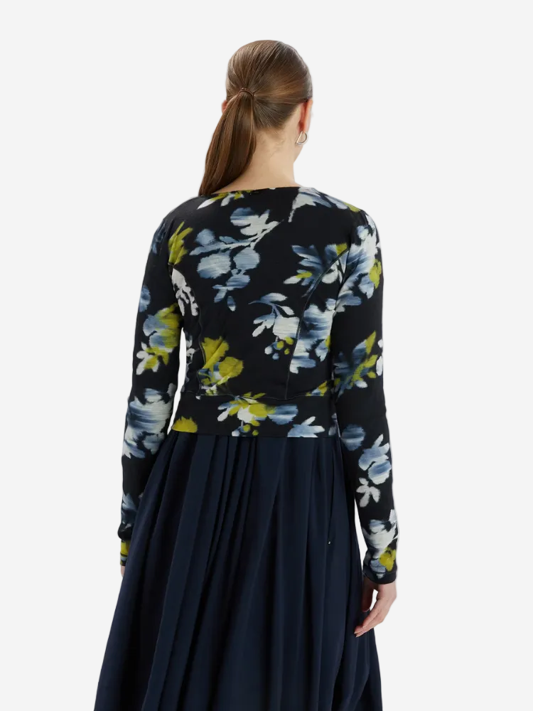 Woman wearing a black floral dress with a plain white background