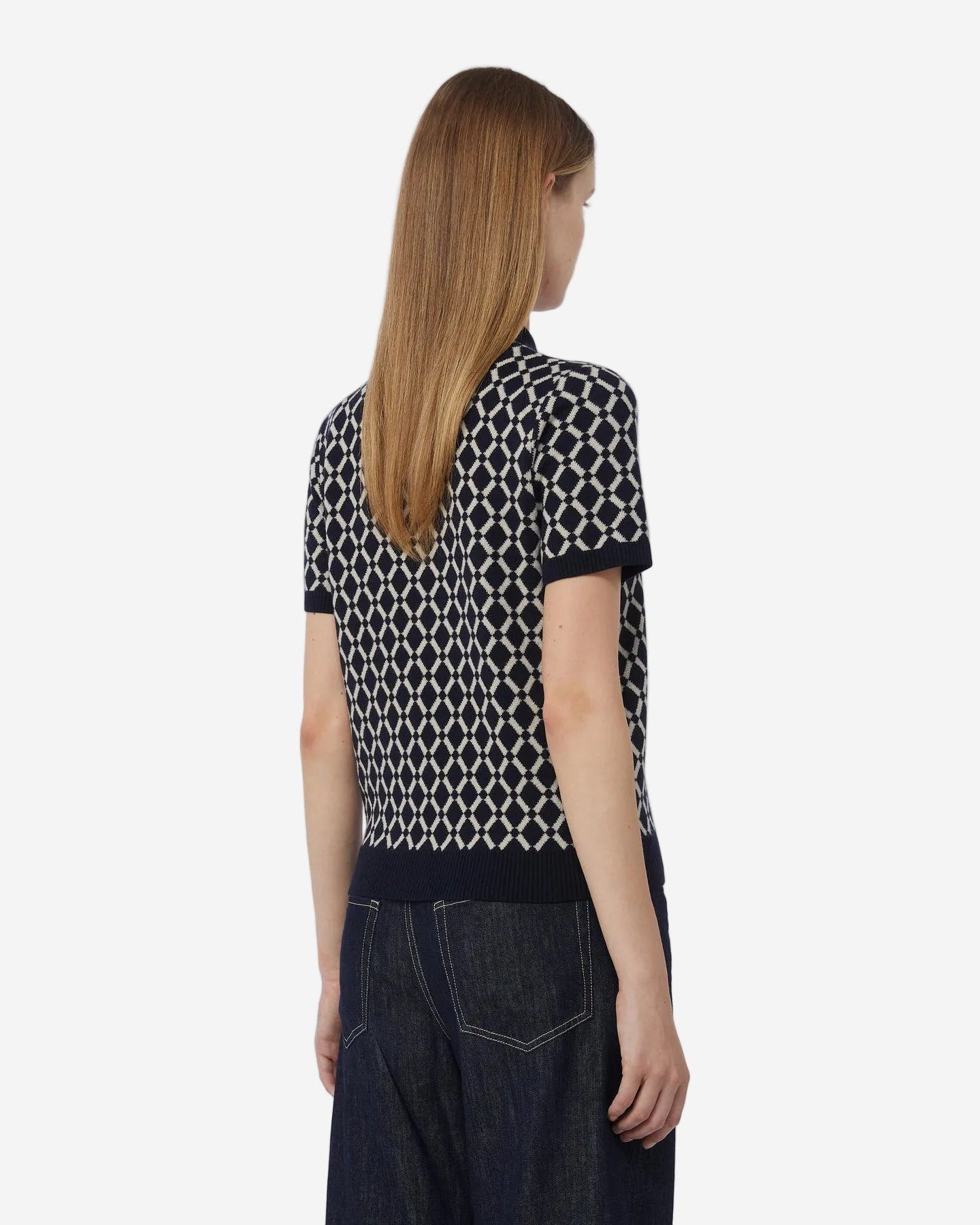 Person wearing a black and white patterned shirt with a plain background