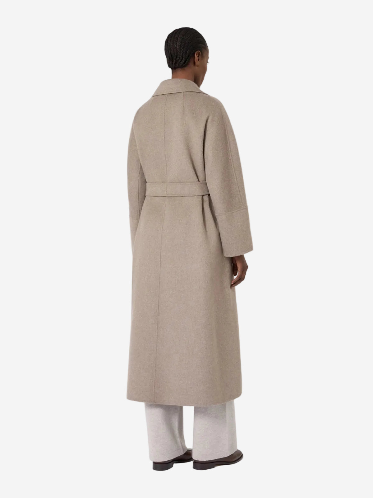 Person wearing a beige trench coat on a white background
